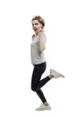 Beautiful woman is jumping. Young laughing blonde woman in black leggings and a gray tank top. Positivity, activity and movement. Royalty Free Stock Photo