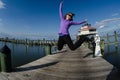 Beautiful woman jumps on a dock alongside the Choptank River Lighthouse in Maryland