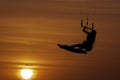 Beautiful woman kitesurfing jump at golden hour girl jumping kiteboarding silhouette at sunset Royalty Free Stock Photo