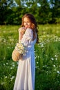 beautiful woman laughing in nature in a chamomile field holding a wicker basket in her hands Royalty Free Stock Photo