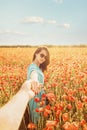 Beautiful woman leading man in poppies meadow. Royalty Free Stock Photo