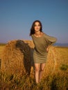 Beautiful woman leaning hay stack enjoying breeze Royalty Free Stock Photo