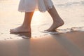 Beautiful woman legs on the beach with sea surf at sunset Royalty Free Stock Photo