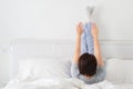 Woman doing some exercise lying in bed with legs high up Royalty Free Stock Photo