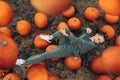 Beautiful woman lies in a field on pumpkins.