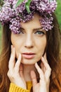 Beautiful woman with lilac flower wreath. Girl in a wreath of lilac in the spring. Royalty Free Stock Photo