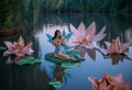 A beautiful woman a little fabulous fairy with butterfly wings sits on green water lily leaf. Fantasy scenery of huge