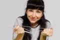 Beautiful woman with long black hair and knitting needles in her hand holding tangled yarn Royalty Free Stock Photo