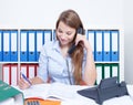 Beautiful woman with long blond hair at office talking at phone Royalty Free Stock Photo