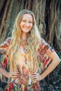 Beautiful woman with long blond hair poses on the background of trees. Portrait of a young long-haired girl Royalty Free Stock Photo