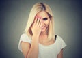 Beautiful woman with long blonde hair wearing white t-shirt, looking shy with hand on face and smiling Royalty Free Stock Photo