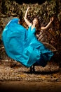 Beautiful woman in long blue dress. Young girl in luxury fashion