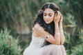 Beautiful woman with long curly hair dressed in boho style dress posing near lake Royalty Free Stock Photo