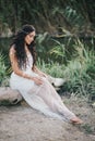 Beautiful woman with long curly hair dressed in boho style dress posing near lake Royalty Free Stock Photo