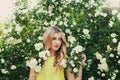 Beautiful woman with long curly hair smells white roses outdoors, closeup portrait of sensual girl face Royalty Free Stock Photo