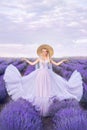 Beautiful woman in a long dress on a background of lavender . A girl in the form of a fairy and a nymph of flowers