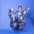 Beautiful woman with long flying dress on blue background Royalty Free Stock Photo