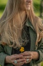 Beautiful woman with long hair holding flower. Hands with rings stylish boho accessories. No focus Royalty Free Stock Photo