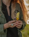 Beautiful woman with long hair holding flower. Hands with rings stylish boho accessories. No focus Royalty Free Stock Photo