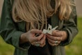 Beautiful woman with long hair holding flower. Hands with rings stylish boho accessories. No focus Royalty Free Stock Photo