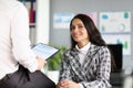 Beautiful woman with long hair in plaid jacket sit opposite director.