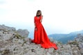 Beautiful woman in a long scarlet dress in a forest in the mountains Royalty Free Stock Photo