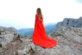 Woman in long red dress on the edge of a cliff in the mountains. Peak of Ai-Petri mountain