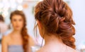 Beautiful woman with long red hair at the beauty salon, hairdresser braided a braid in a beauty salon. Professional hair care and Royalty Free Stock Photo