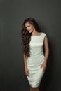 Beautiful woman with long wavy hair in white perfect dress. Brunette fashion model with curly hairstyle Royalty Free Stock Photo