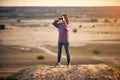 Beautiful woman looking through binoculars outdoors at sunset Royalty Free Stock Photo