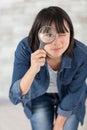 beautiful woman looking at camera through magnifying glass Royalty Free Stock Photo