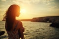 Beautiful woman looking into the distance at sunset against the sky