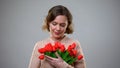 Beautiful woman looking at flowers from admirer, romantic present, anniversary