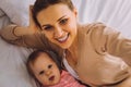 Beautiful woman looking happy while taking selfie with her baby daughter Royalty Free Stock Photo