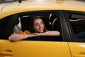 Beautiful young woman looking out of taxi window outdoors