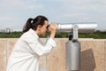 Beautiful woman looking through tourist binocular telescope Royalty Free Stock Photo