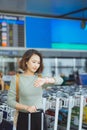 Beautiful woman looks at the clock waiting for the plane at the airport Royalty Free Stock Photo