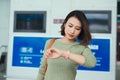 Beautiful woman looks at the clock waiting for the plane at the airport Royalty Free Stock Photo