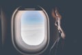 Beautiful woman looks out the window of an flying airplane. Pass Royalty Free Stock Photo