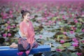 Beautiful woman with lotus flower at the red lotus sea Royalty Free Stock Photo