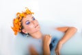 Beautiful woman lying in bath with flowers Royalty Free Stock Photo