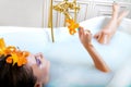 Beautiful woman lying in bath with flowers Royalty Free Stock Photo