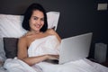 Beautiful woman lying in bed and making a phone call. Young girl using her laptop at home. Beautiful woman relaxing at Royalty Free Stock Photo