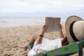 A woman lying down and reading book on the beach chair with feeling relaxed Royalty Free Stock Photo