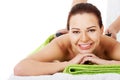 Beautiful woman lying on spa salon having stone massage. Royalty Free Stock Photo