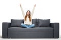 Beautiful woman lying on a white sofa with raised hands isolated on white background Royalty Free Stock Photo