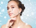 Beautiful woman with magnifier on face over snow Royalty Free Stock Photo
