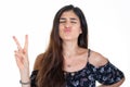 Beautiful woman makes a v with her fingers victory sign and a kiss with her mouth