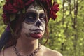 Beautiful woman in makeup traditional Mexican Calavera skull Katrina in the autumn forest, in a wreath of red flowers. Day of the Royalty Free Stock Photo