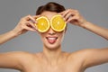 Beautiful woman making eye mask of orange slices Royalty Free Stock Photo